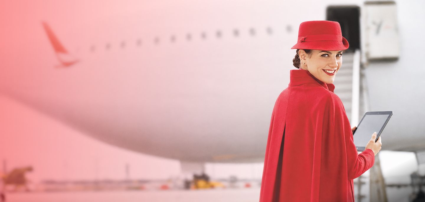 Colaboradora de Avianca con uniforme rojo utilizando una tableta