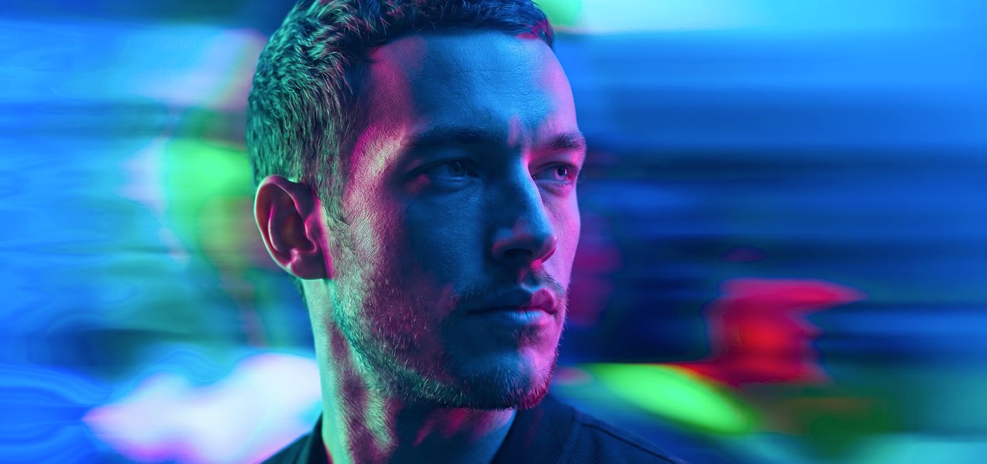 Rostro de un hombre entre luces de neón azules y verdes