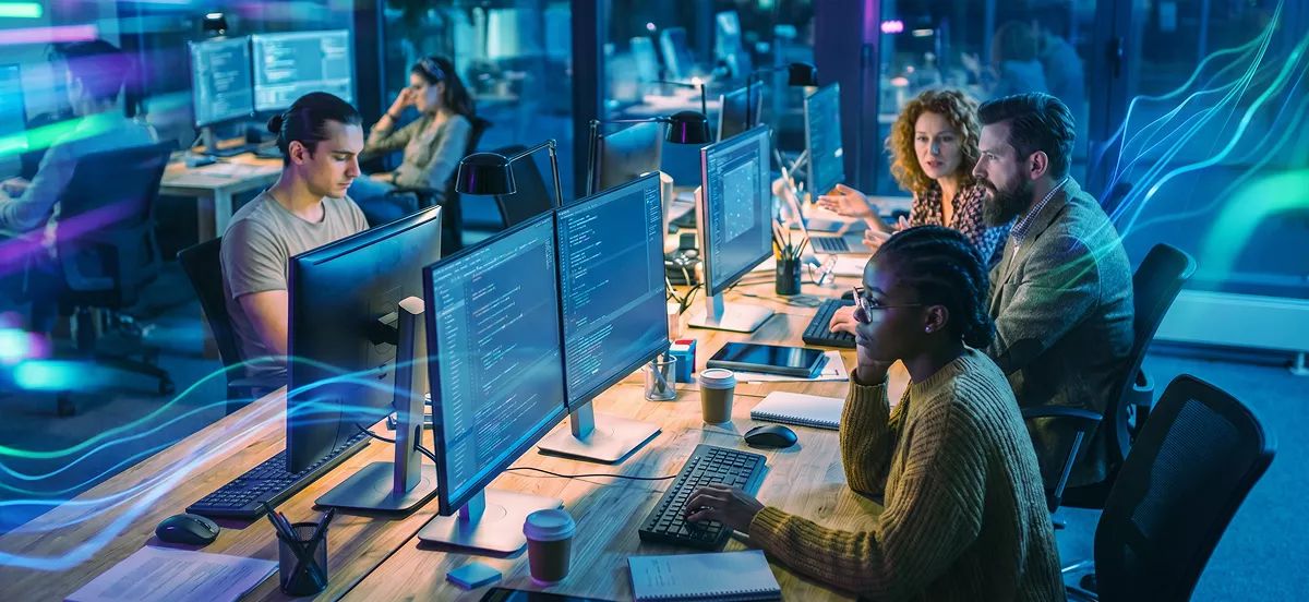 Equipo de desarrollo trabajando frente a monitores