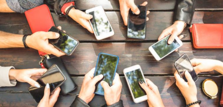 Muchos celulares sontenidos con las manos